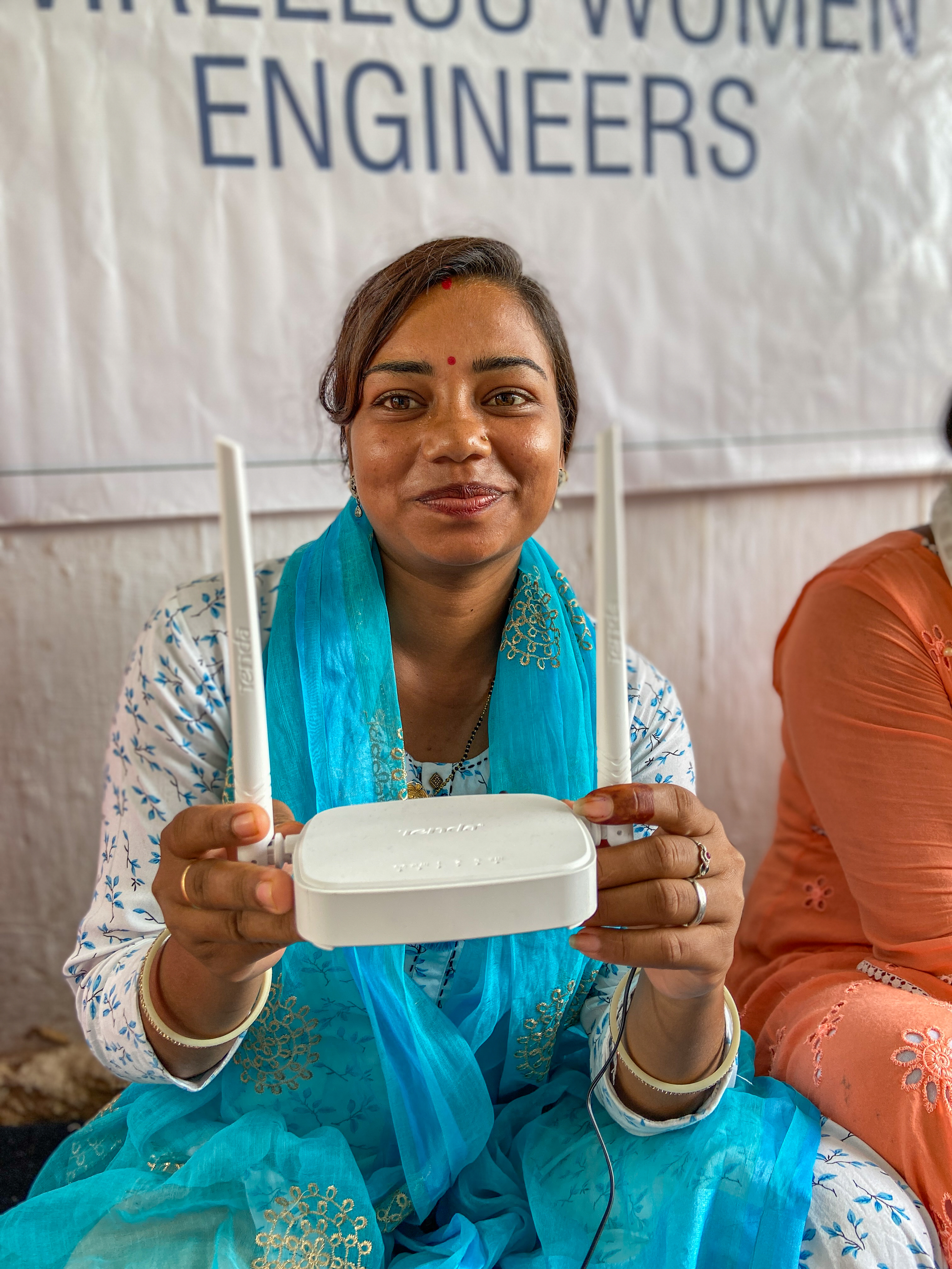 A woman in rural India shows the wireless network router she uses during training under DEF’s Women Wireless Engineers programme