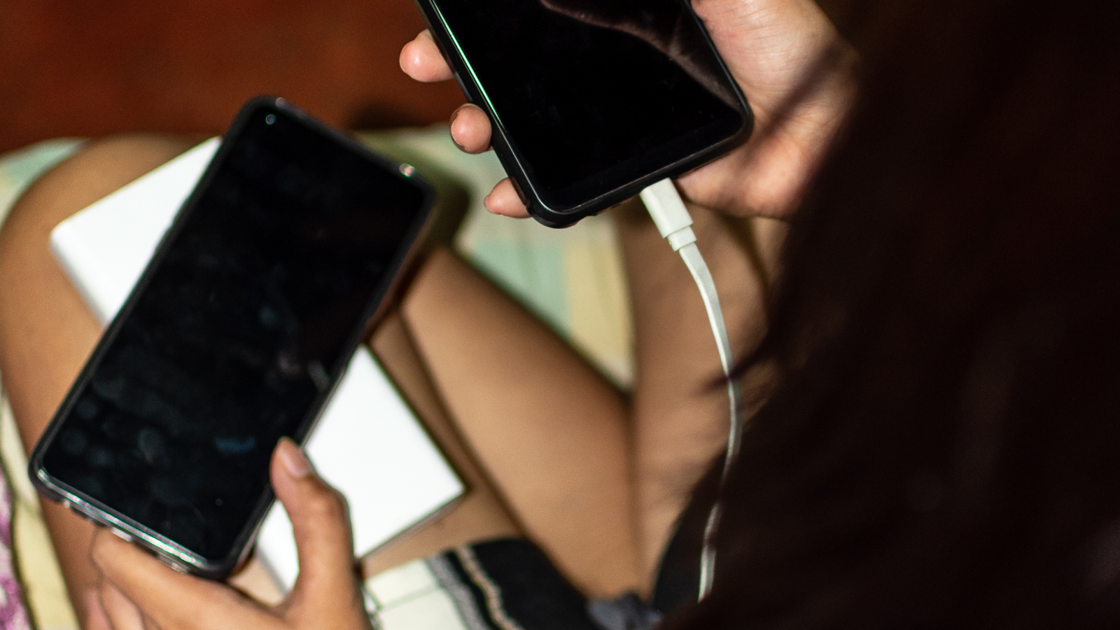 A woman charging her phone on a portable power bank to stay connected