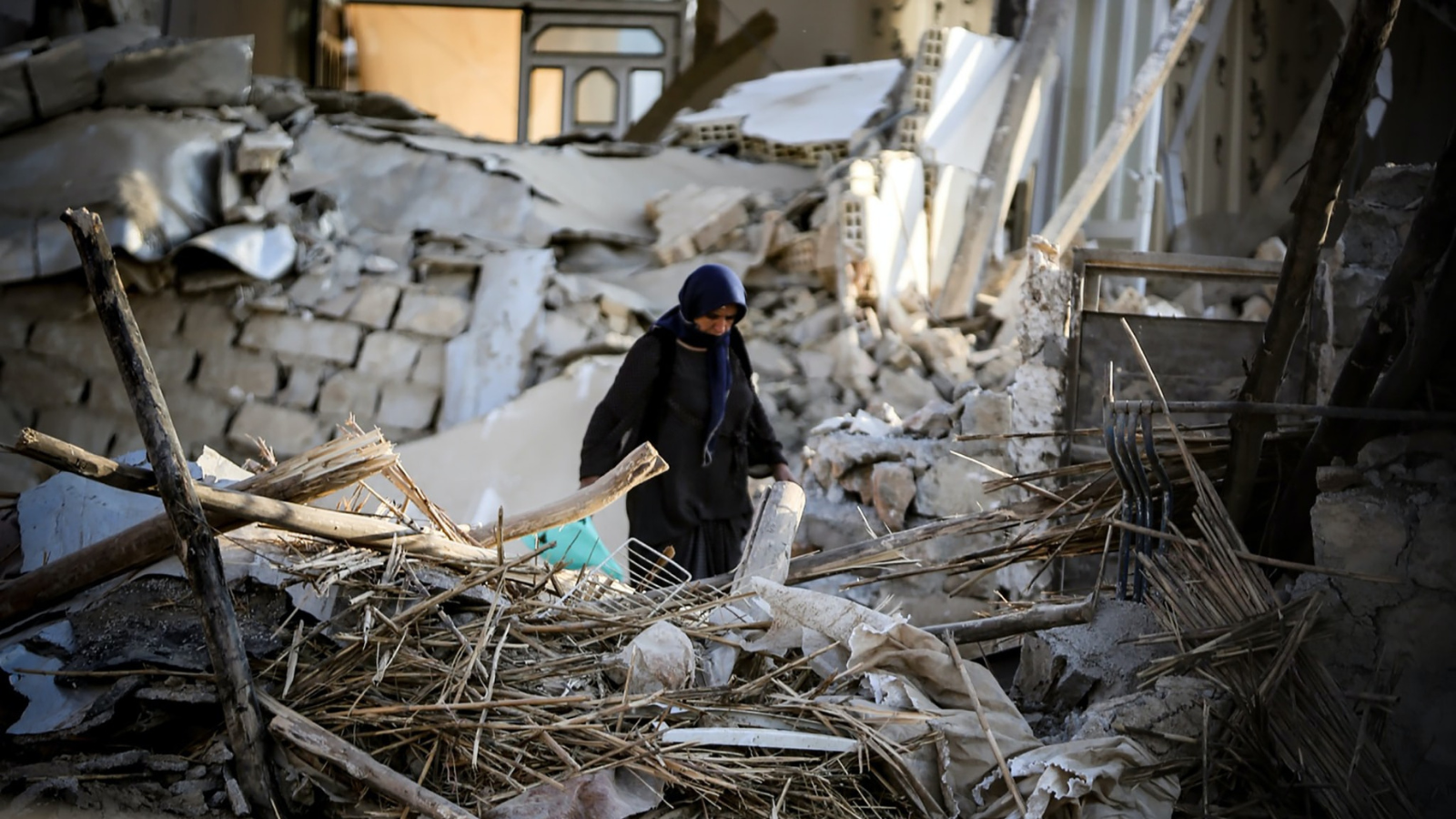 A woman in the middle of a heavily damaged building after a 6.3-magnitude earthquake in Kermanshah, western Iran