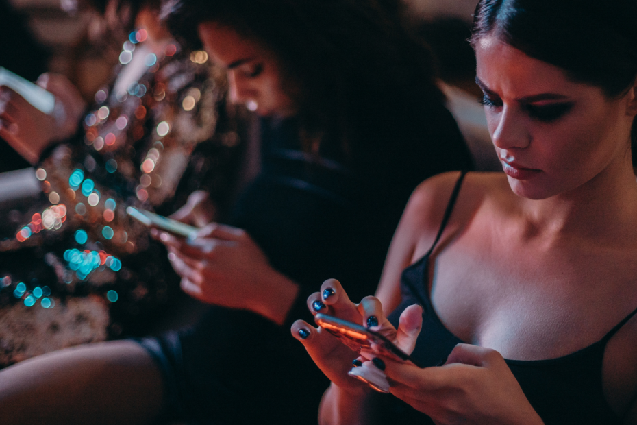 A group of women using their smartphones while sitting together