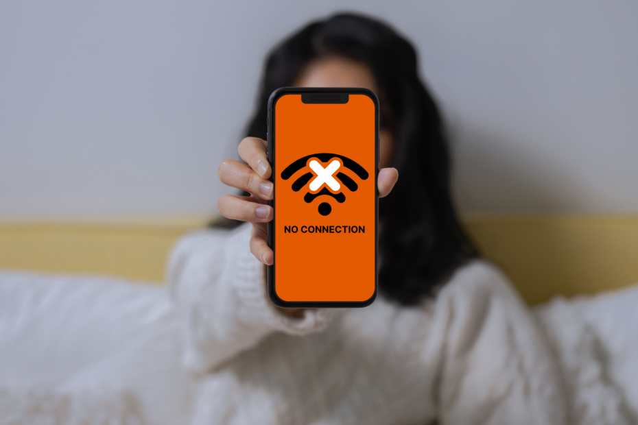 A woman showing her smartphone with no connection GDIP orange
