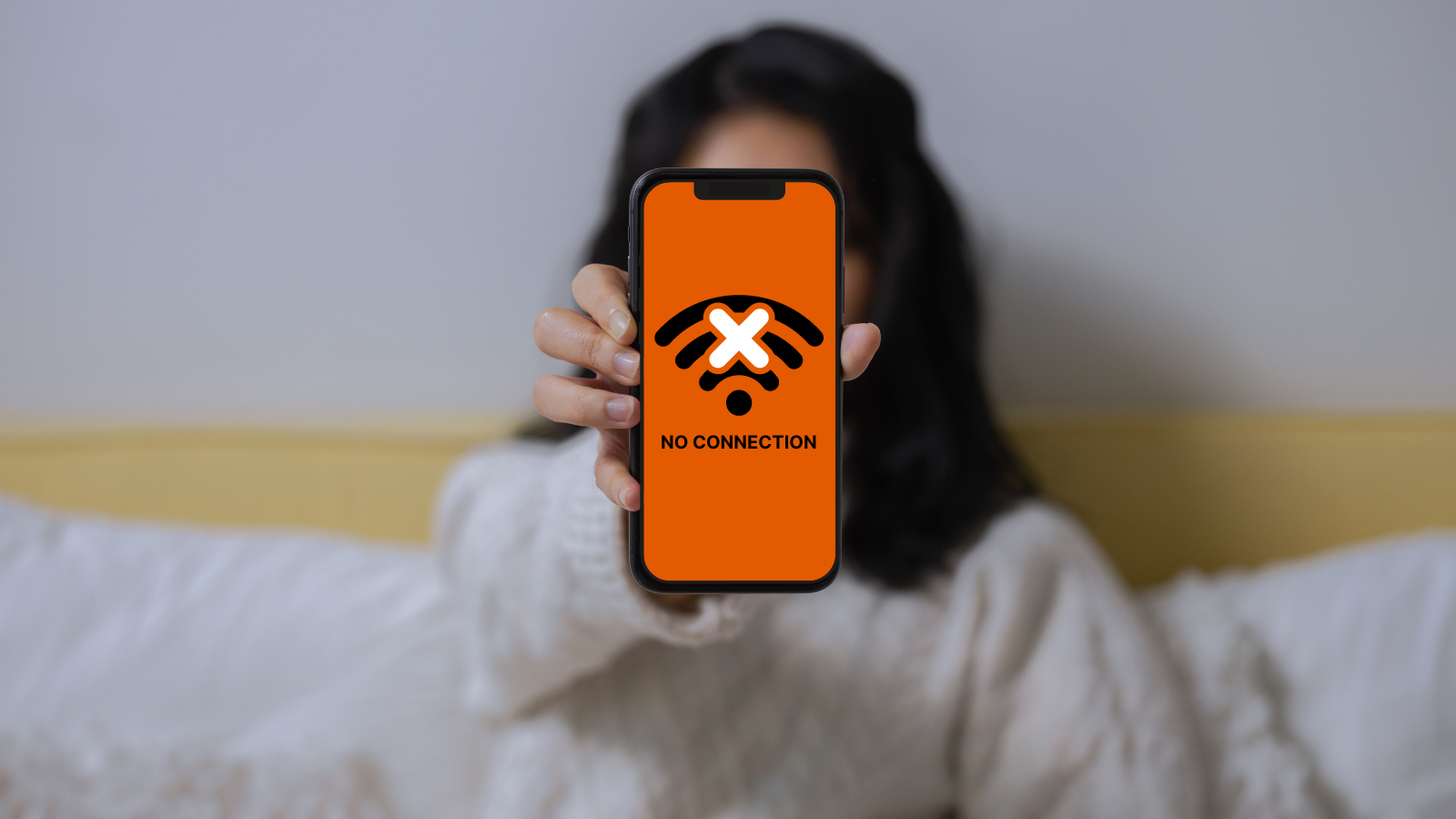 A woman showing her smartphone with no connection GDIP orange